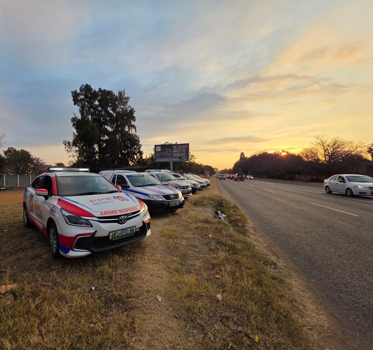 The RPS Security vehicle fleet lined up beside a Rustenburg road at sunset