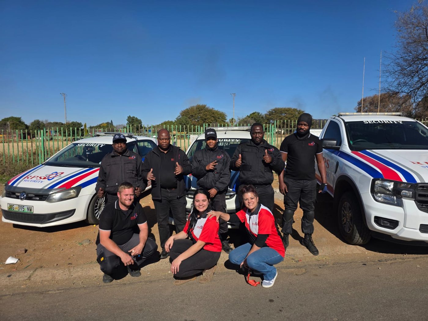 The RPS Security team standing with two marked armed response vehicles in Rustenburg